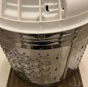 The inside of a washing machine tub with its metal surface visible after cleaning